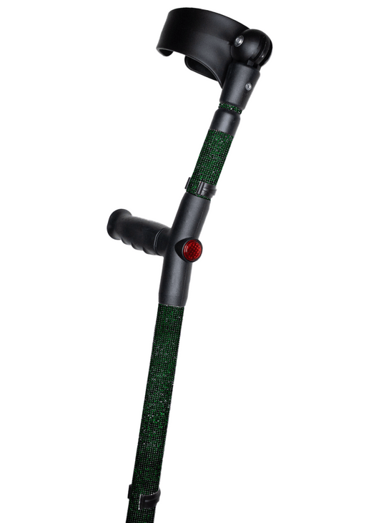 Crutch with a black handle and cuff decorated with dark green coloured glass rhinestones.  The crutch also has a red reflective circle at the back and the front of the handle.