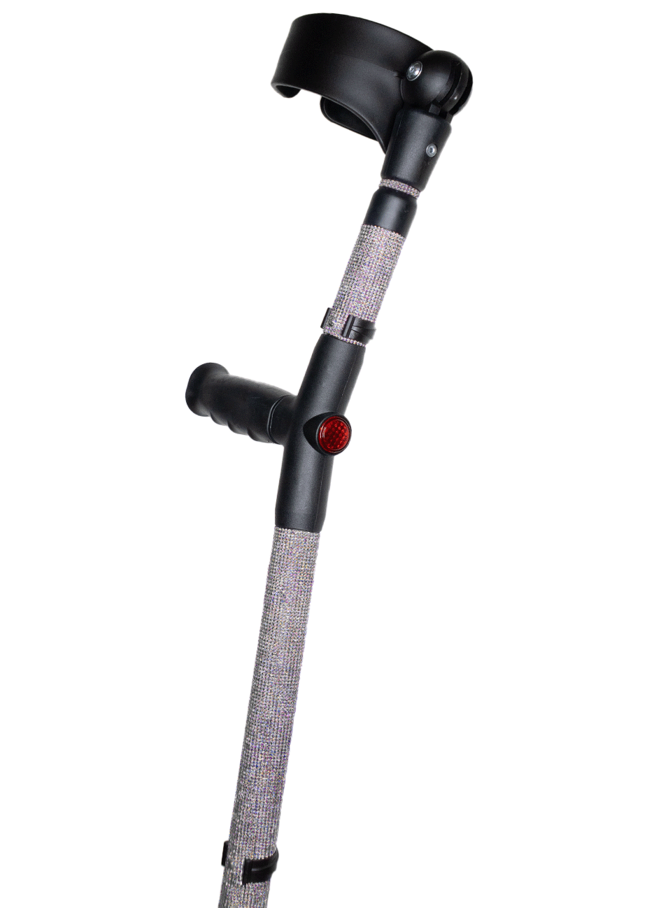 Crutch with a black handle and cuff decorated with clear coloured glass rhinestones.  The crutch also has a red reflective circle at the back and the front of the handle.