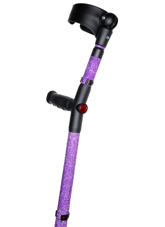 Crutch with a black handle and cuff decorated with purple coloured glass rhinestones.  The crutch also has a red reflective circle at the back and the front of the handle.