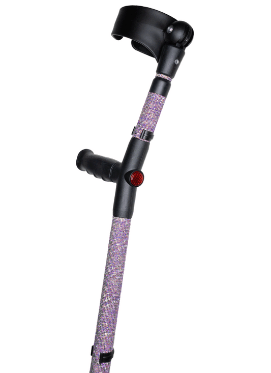 Crutch with a black handle and cuff decorated with lilac coloured glass rhinestones.  The crutch also has a red reflective circle at the back and the front of the handle.